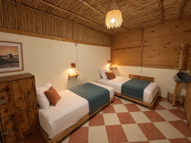Twin beds with blue cushions and a patterned tile floor
