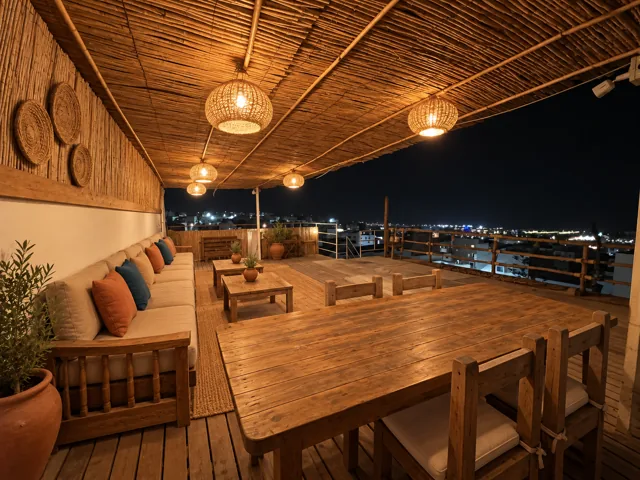 The rooftop terrace with shared tables and warm lighting after dark